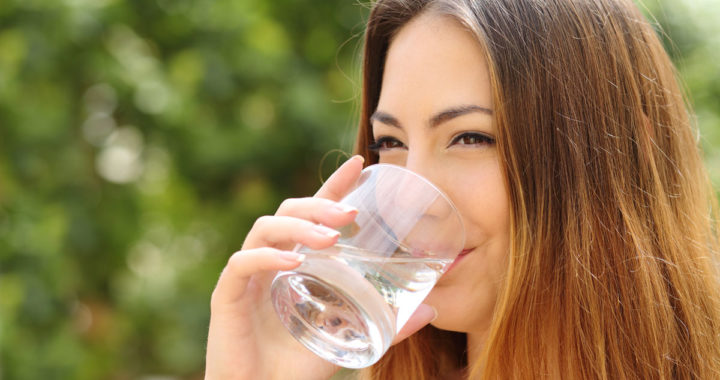 mulher bebendo água para se hidratar