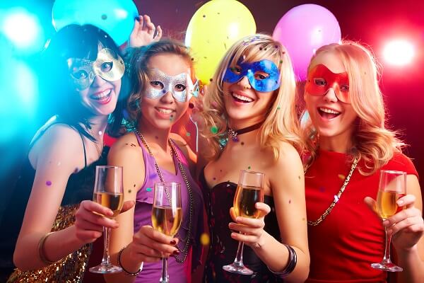 mulheres-com-máscaras-de-carnaval-seguram-taças-de-bebidas